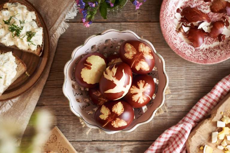 Brown Easter eggs dyed with onion skins, with slices of sourdough bread with spread made of leftover hard-boiled eggs, top view