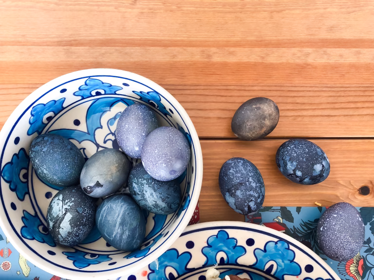 Cosmic Easter eggs dyed in hibiscus tea for Orthodox Easter. Deep blue, purple, and marbled textures create a galaxy effect with natural dye for holiday Easter tradition. High quality photo