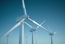 Zakaj se vetrnic ne da recikliratI? White wind turbine generating electricity on blue sky