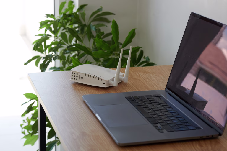 Wifi router and laptop on desk on freelancer working from home