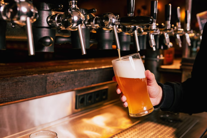 bartender-pouring-light-cold-foamy-beer-from-tap-into-glass-at-bar-with-multiple-beer-dispensers-serving-craft-beer-from-tap-concept-of-alcohol-drinks-nightlife-party-festivals-beer-fest-ad-stockpack-istock Bartender pouring light, cold foamy beer from tap into glass at bar with multiple beer dispensers. Serving craft beer from tap. Concept of alcohol drinks, nightlife, party, festivals, Beer Fest. Ad