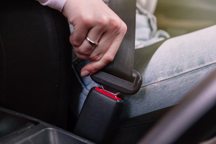 close-up-image-of-business-woman-sitting-in-a-car-putting-on-her-seat-belt-stockpack-istock Close up image of business woman sitting in a car putting on her seat belt