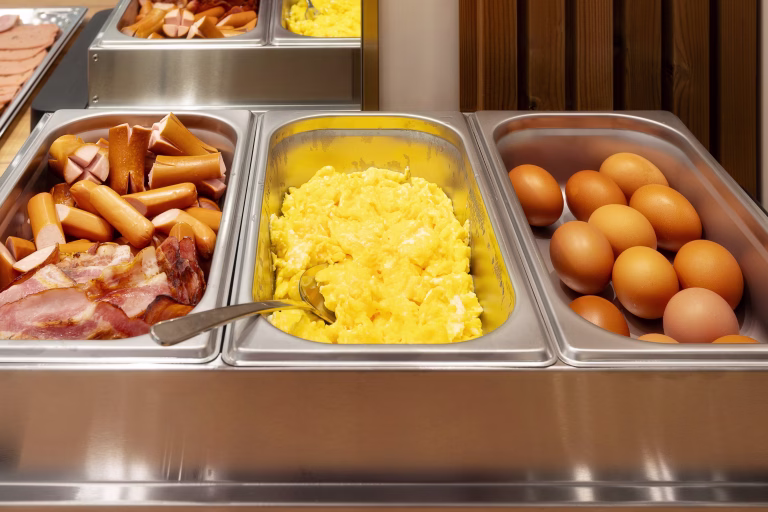 Diverse Breakfast Buffet Selection with hot sausages, ham, scrambled and boiled eggs