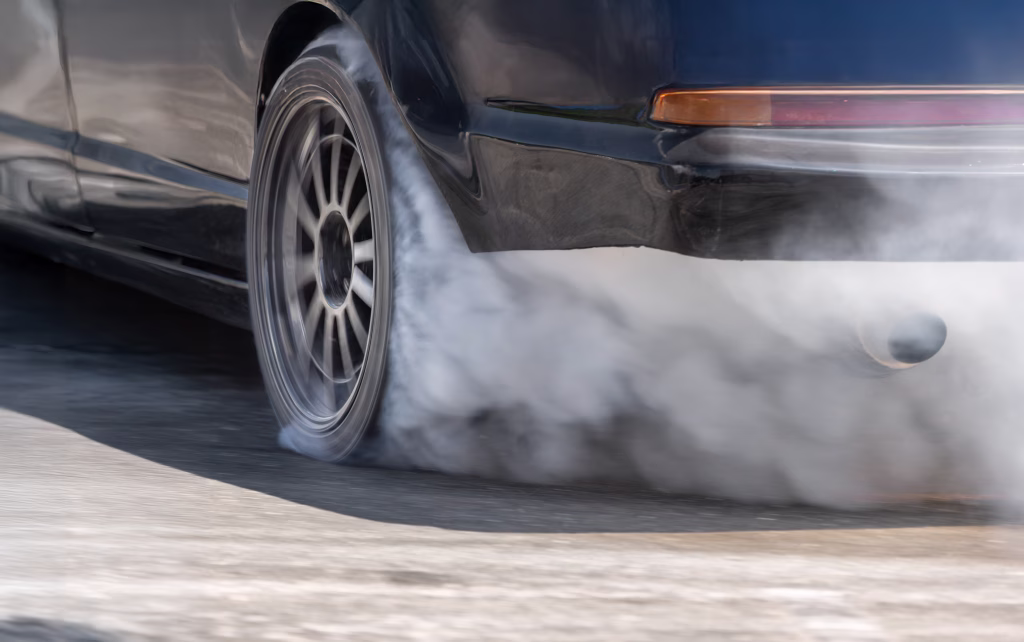 Race drift car burning tires on speed track.