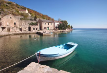 V tem mestecu največ letujejo Čehi, Slovaki, Ukrajinci in Slovenci, apartmaje pa je mogoče najti tudi za 40 evrov v glavni sezoni Blue wooden fishing boat moored in fishing village along the coast of Croatia