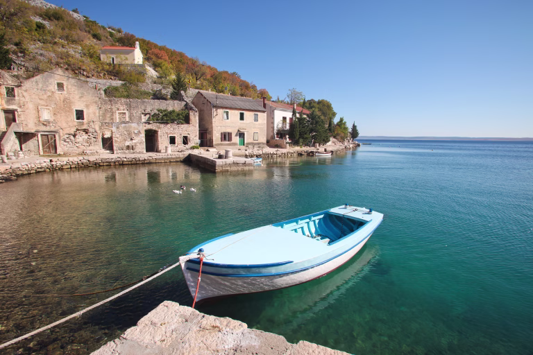 Blue wooden fishing boat moored in fishing village along the coast of Croatia
