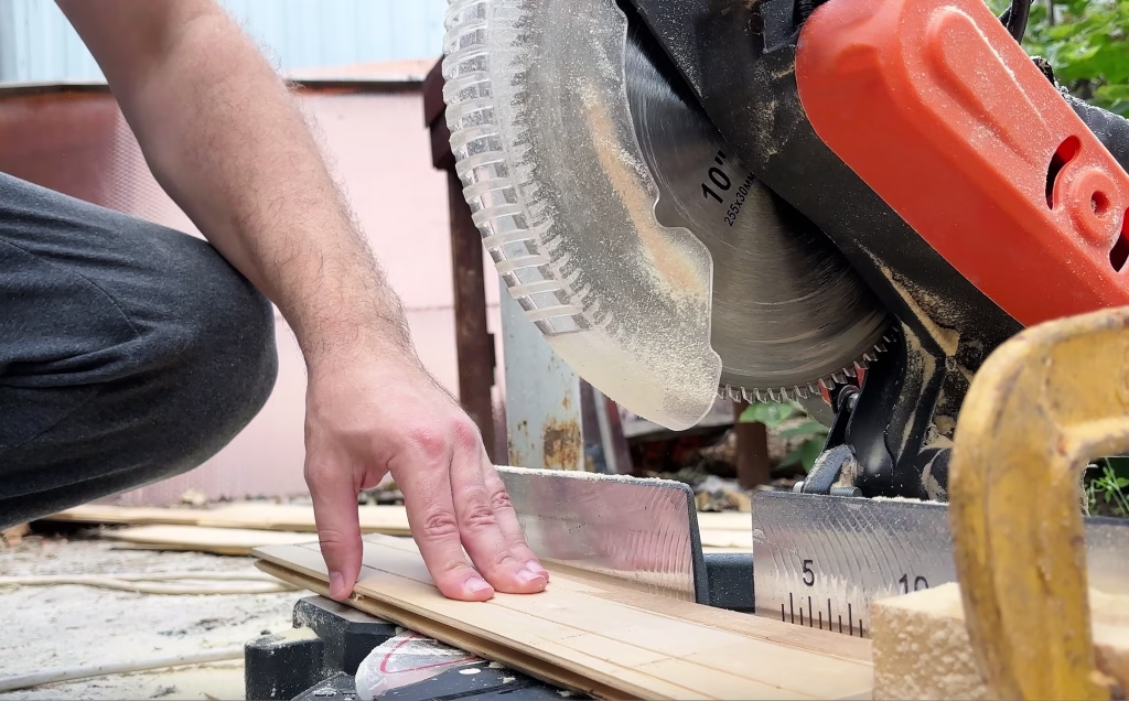 Circular saw for cutting wooden panel made of fiberboard in workshop. Carpenter equipment for Medium Density Fiberboard (MDF) processing. Woodworking machine with a electric circular saw. Woodworking
