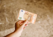 Ni dosti denarja v hiši? Samo položite bankovec na to mesto in opazujte, kako se denar začne kopičiti Hand holding a 50 euros banknote as background. Euro cash background. Close up view of euro banknote in hand.