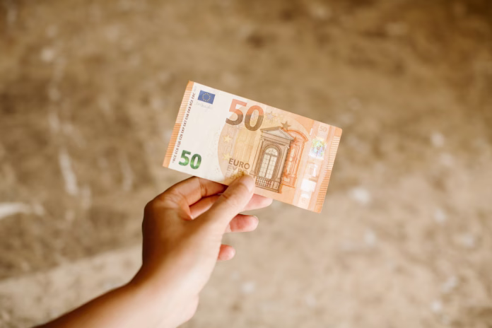 hand-holding-a-50-euros-banknote-as-background-euro-cash-background-close-up-view-of-euro-banknote-in-hand-stockpack-istock Hand holding a 50 euros banknote as background. Euro cash background. Close up view of euro banknote in hand.