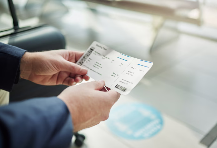 Plane ticket in hands, travel and person at airport, waiting on flight for business trip, check in and boarding. Closeup, professional conference or convention with travelling for work and journey