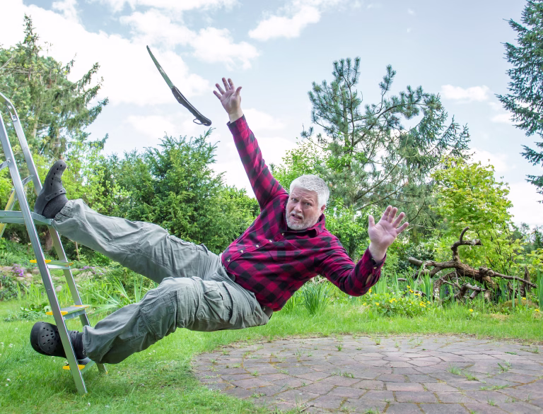 Portrait Of Senior Man Falling From Ladder In Yard Against Sky