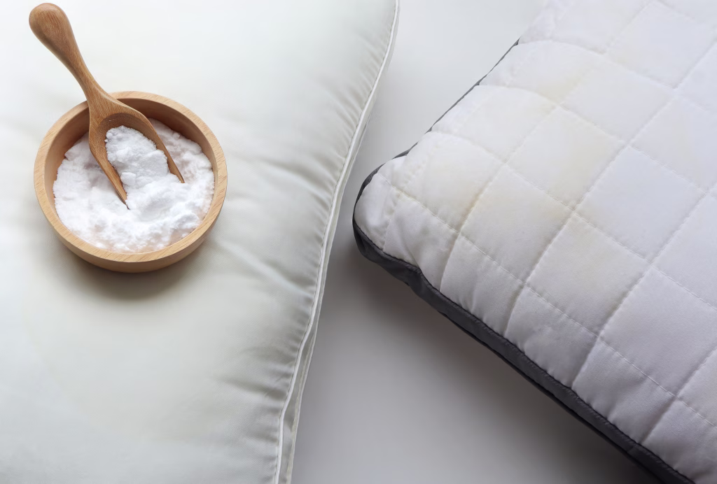 White pillow with yellow saliva stains and baking soda (sodium bicarbonate) on white background. baking soda to clean their dirty mattresses and Home cleaning concept.