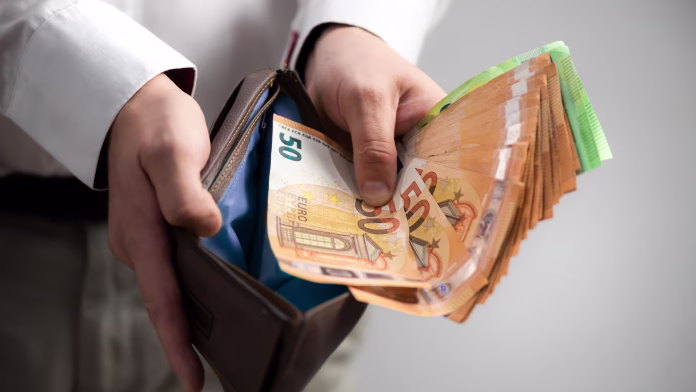 Pulling a euro banknotes from the wallet.