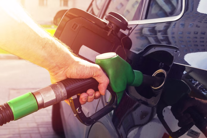 Refuelling the car at a gas station fuel pump. Man driver hand refilling and pumping gasoline oil the car with fuel at he refuel station. Car refuelling on petrol station. Fuel pump at station