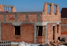 Na teh občinah že lahko pridobite elektronsko gradbeno dovoljenje – je čakanja zato manj? Single-family home made of hollow blocks or bricks. New unfinished stand-alone house building under construction.