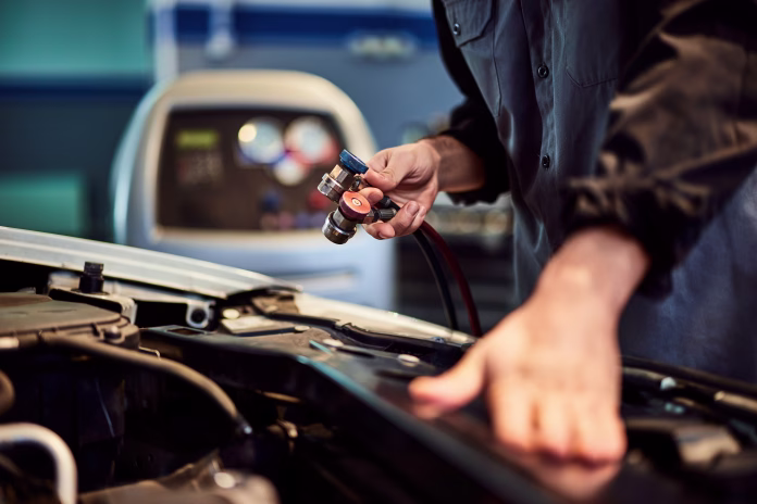 The male mechanic used a machine to file air conditioner and repair the car.