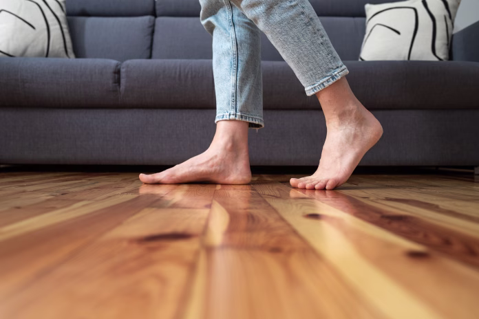 cropped-shot-of-female-legs-walk-barefoot-on-wooden-warm-floor-near-couch-in-living-room-at-home-heating-concept-stockpack-istock cropped shot of female legs walk barefoot on wooden warm floor near couch in living room at home, heating concept