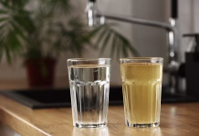 Čistilne naprave za pitno vodo, kako deluje in kakšne so prednosti House water filtration system to drinkable condition. Glass of clear water after reverse osmos filtration and glass of dirty water on tabletop on kitchen. Evidence of contamination of tap water.