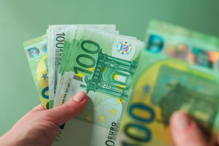 salary of a woman. euro banknotes in hands on a green background. Income of women in European countries