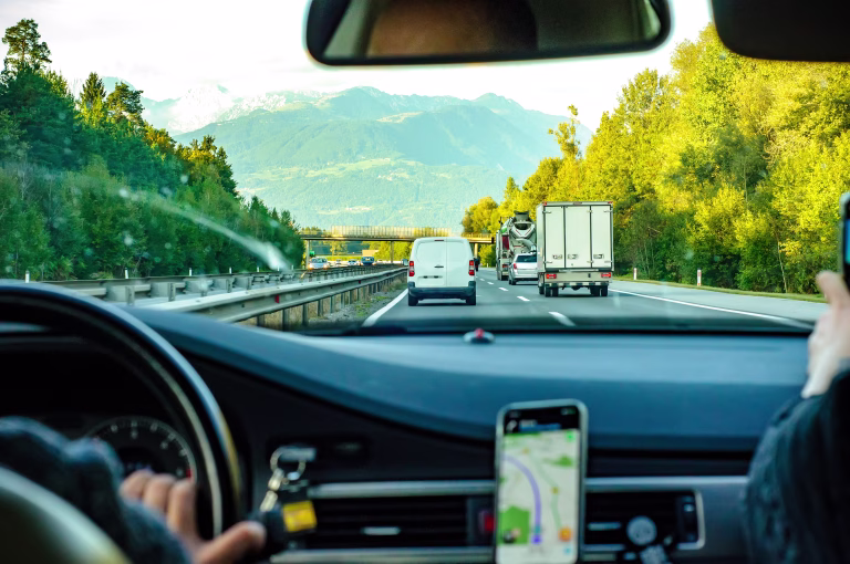 Photo of a roadtrip in Slovenia on a highway with the mountains in the background.
