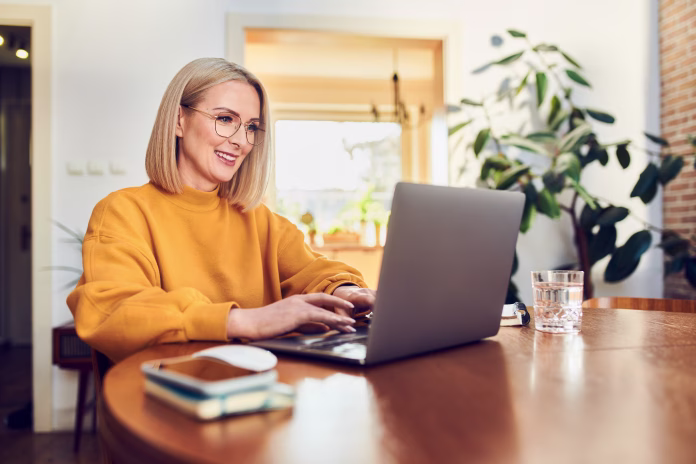 portrait-of-middle-aged-woman-sitting-at-dinning-with-laptop-working-at-home-stockpack-istock Portrait of middle aged woman sitting at dinning with laptop working at home