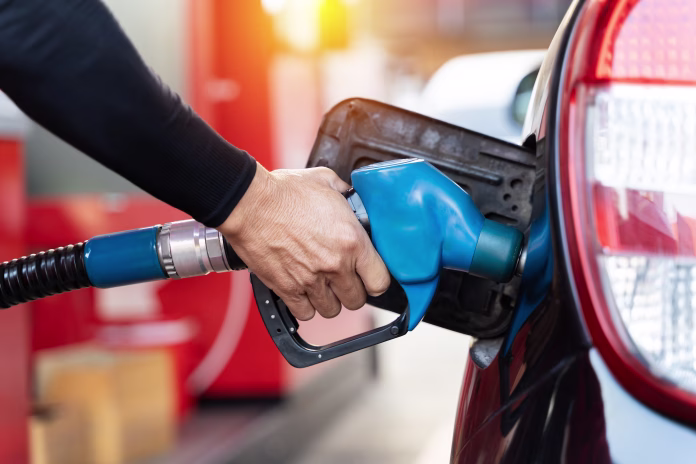 Refueling the car at a gas station fuel pump. Man driver hand refilling and pumping gasoline oil the car with fuel at he refuel station. Car refueling on petrol station. Fuel pump at station
