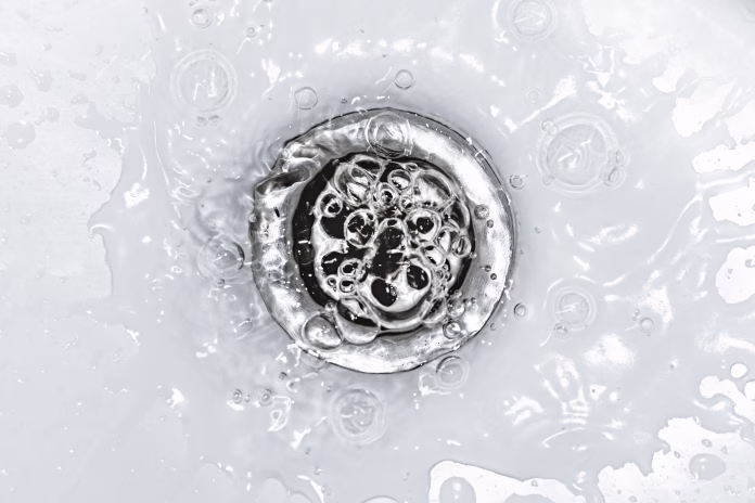 Slow bathroom sink drain. Household plumbing problem. Water draining down slowly in wash basin. Drain cleaning and unclog