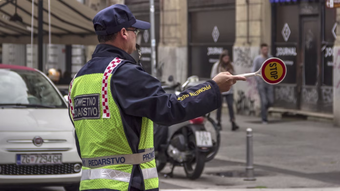 Obveznost prižiganja luči samo v obdobju zimskega časa je utemeljena z ekološkimi razlogi. FOTO: Shutterstock Zagreb, Croatia, November 05th 2018: Traffic Police Officer regulates the traffic in Ilica Street at morning rush hour.