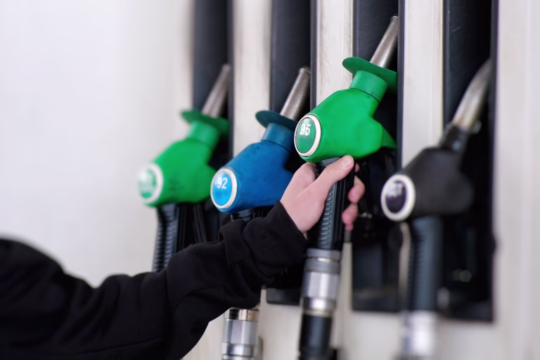 A closeup view of vibrant fuel pumps at a bustling service station, fully prepared for vehicle refueling at any moment