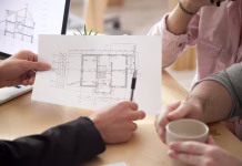 Najpogostejše napake pri pridobivanju gradbenega dovoljenja in drugih dokumentov Architect or interior designer showing new apartment plan to couple at meeting, Real Estate Agent consulting customers making real estate offer, mortgage loan investment and construction concept, close up view