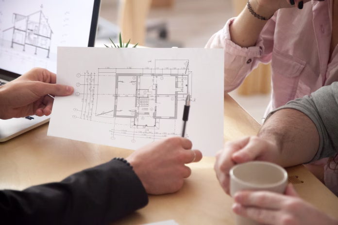 Architect or interior designer showing new apartment plan to couple at meeting, Real Estate Agent consulting customers making real estate offer, mortgage loan investment and construction concept, close up view