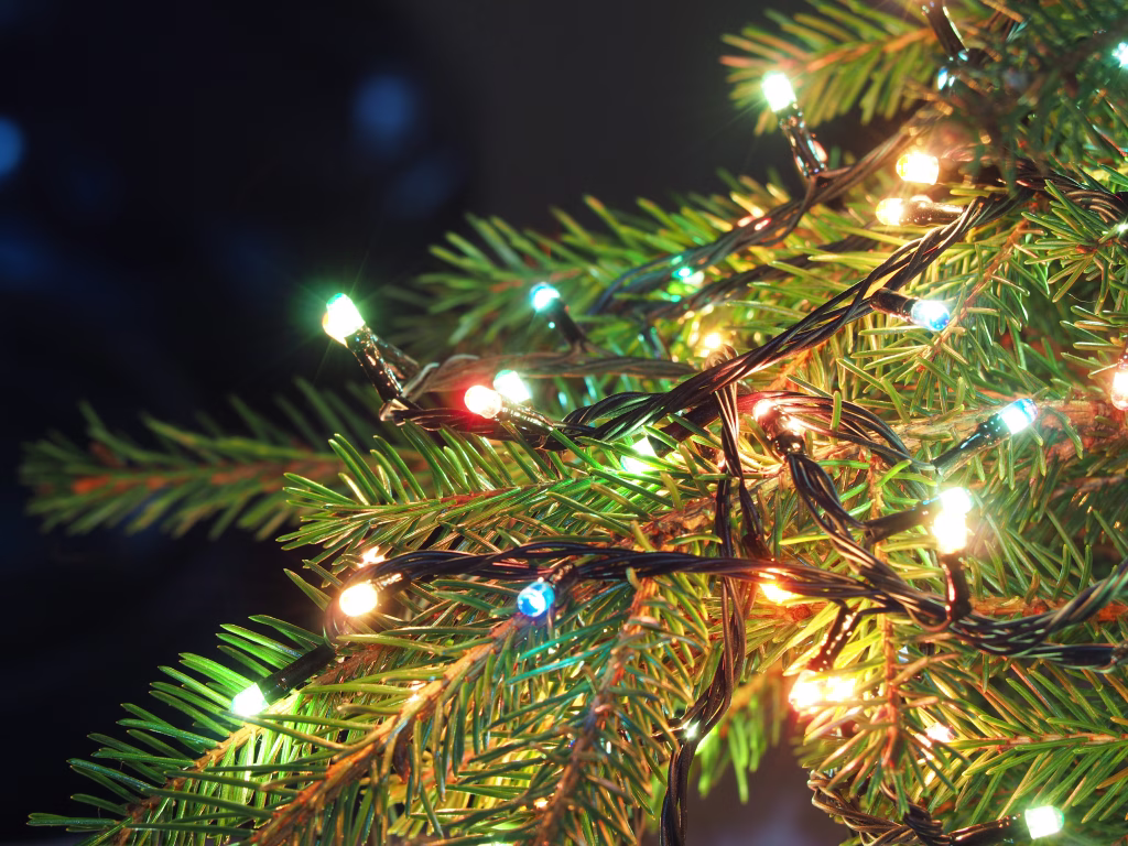 Christmas lights on Christmas tree, decorative garland in dark space