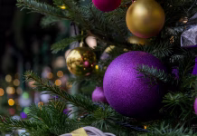 Ta datum je ključen, da pospravite jelko! Če tega ne storite, ne pričakujte lepega leta Colorful ornaments hang from a well-decorated evergreen tree along a bustling street. The warm glow of lights creates a cheerful atmosphere, inviting passersby to enjoy the holiday spirit.