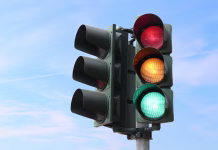 Beli semafor? Četrta luč, ki bi lahko za vedno spremenila križišča Traffic light isolated in the sky with all the lights on.