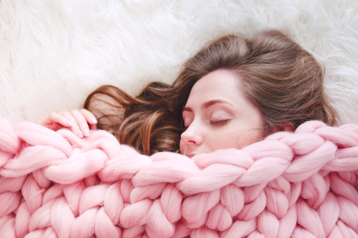 young-woman-with-long-brown-hair-sleeping-under-warm-knitted-peach-color-throw-blanket-stockpack-istock Young woman with long brown hair sleeping under warm knitted peach color throw blanket