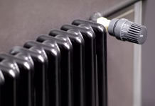 Zakaj so črni radiatorji postali hit? Lastniki pravijo, da grejejo močneje in znižajo račune A sleek black radiator with an adjustable thermostat for optimal heating comfort and efficiency in your space