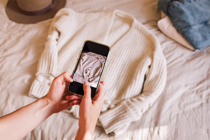 close-up-of-womans-hands-taking-picture-of-her-used-sweater-selling-used-clothes-online-reuse-sustainable-consumption-stockpack-istock Close-up of woman's hands taking picture of her used sweater. Selling used clothes online, reuse, sustainable consumption
