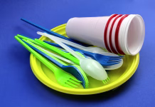 Teh stvari ne smete uporabiti dvakrat! Mnogi jih operejo in znova uporabijo, to je velika napaka … Disposable tableware in a pile lie on a blue background.