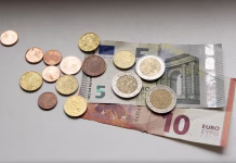 Slaba vest! Za toliko bo višji obvezni zdravstveni prispevek Euro coins with five and ten Euro bills on table