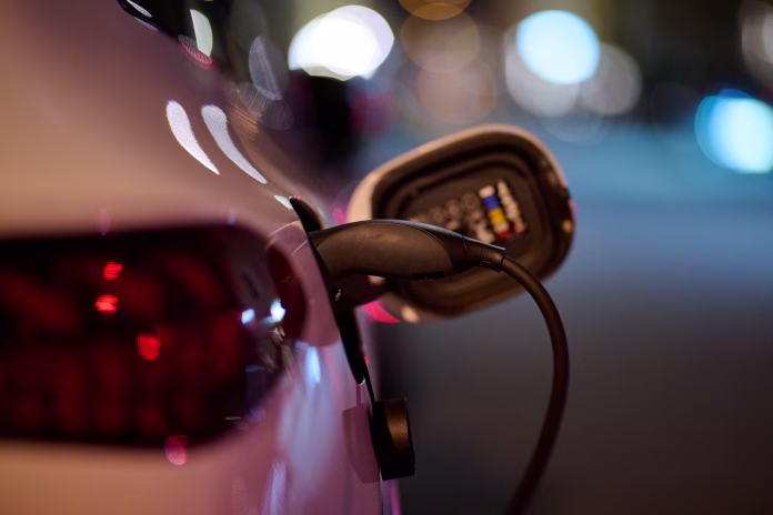 EV charger plugged in a electric car at night