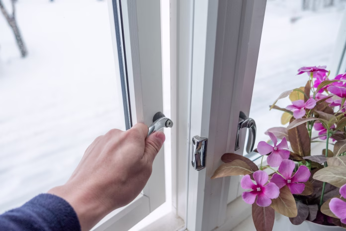 Hand opening window with flower decoration in winter