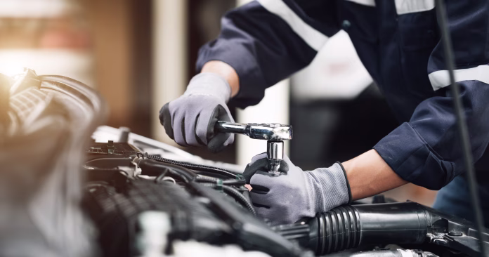 Mechanic works on the engine of the car in the garage. Repair service. Concept of car inspection service and car repair service.