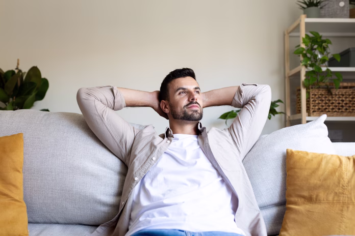 Young man enjoys a moment of tranquility at home, resting on his comfortable sofa