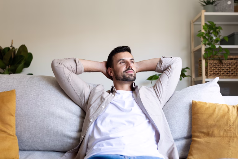 Young man enjoys a moment of tranquility at home, resting on his comfortable sofa