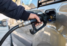 Prihaja nov šok na črpalkah: to se bo v torek zgodilo z dizlom in bencinom Hand of man driver holding fuel pump and refilling gasoline tank of car with fuel at gas station.