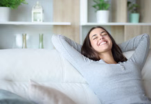 Zakaj je prezračevanje doma pomembnejše, kot si večina misli Happy woman resting sitting in a comfortable couch at home