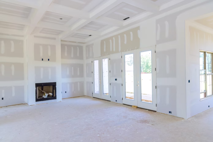 Plastering drywall in preparation for painting in newly constructed house