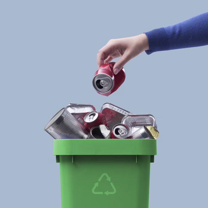 Woman throwing a metal can in the recycling bin, separate waste collection concept