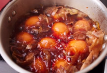 Letos boste imeli najlepša rdeča velikonočna jajca: potrebujete le 3 sestavine, ki jih ima vsak dom Saucepan with boiled chicken eggs with onion husks. Coloring eggs in natural dyes for the Easter holiday. Close-up