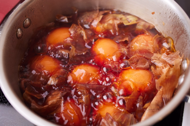 Saucepan with boiled chicken eggs with onion husks. Coloring eggs in natural dyes for the Easter holiday. Close-up